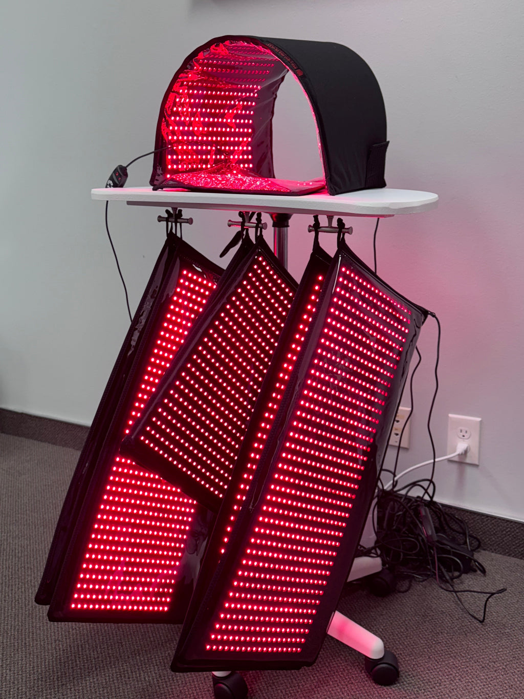 Red LED panel system on a stand against a plain wall.